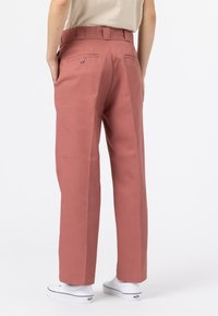 Růžové kalhoty se střihom rovného nohavice, vyrobené z bavlněné směsi, s dvěma zadními kapsami na knoflíky a poutkem na pásek.