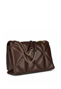 Borsa a tracolla in pelle trapuntata marrone scuro con catene dorate su uno sfondo bianco, inclinata per mostrare la texture e i dettagli del design.