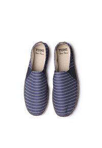 Jūros mėlynos espadrilės be raištelių su baltomis juostelėmis, pagamintos iš kvėpuojančios medžiagos, turinčios elastingas šonines dalis ir jūroje rastą natūralaus pluošto pado tekstūrą.