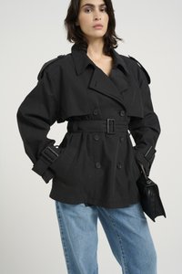 Must mustriga kahekordse eest lukuga musta vööga trench coat, laia krae ja nööbitud mansettidega. Sobitatud helesiniste mahukate teksade ja musta käekotiga.