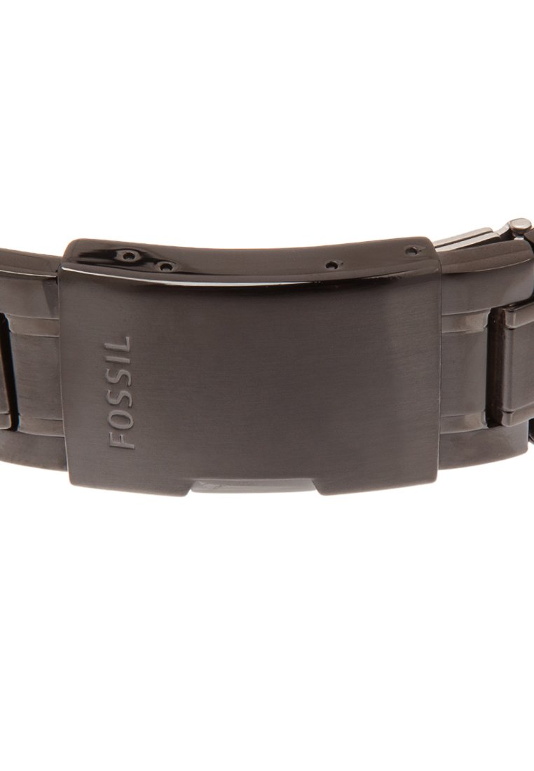 Reloj de pulsera negro con un acabado suave y pulido. Presenta un cierre de enganche y el logotipo "FOSSIL" grabado en la correa ajustable.