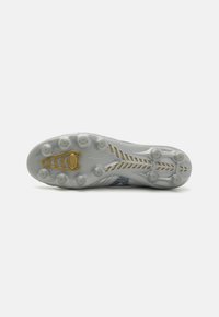 Voetbalschoen zool met een heldere rubberen basis, gouden accenten en strategisch geplaatste studs. Heeft een textuurontwerp voor verbeterde grip.