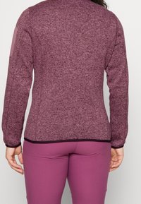 Sukkulente, langärmlige Pullover in einem satten Pflaumenfarbton, mit einem kontrastierenden Saum und Ellbogen-Patches. Sanfter Strickstoff, gerippte Bündchen.