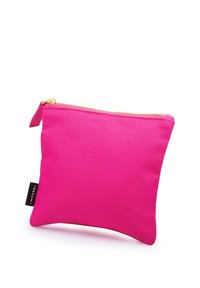 Pink fabric pouch with gold zipper, rectangular shape, textured surface, and a small black tag on the side displaying “YOKOAMII.”