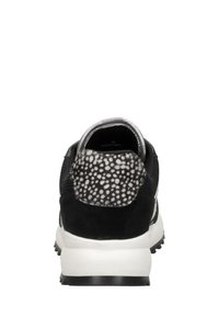 Schwarzer Sportschuh mit einem strukturierten, schwarz-weißen gepunkteten Rücken, Obermaterial aus Mesh und weißer Sohle. Verfügt über einen kontrastierenden metallischen Besatz am Schuhrand.