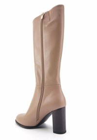 Beige Lederstiefel bis zur Kniehöhe mit Blockabsatz und seitlichem Reißverschluss. Glatte Oberfläche mit leicht spitz zulaufender Zehenpartie und strukturierter Silhouette.