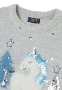Hellgrauer Pullover mit Rundhalsausschnitt, der ein flauschiges weißes Einhorn-Design, eine blau glitzernde Mähne sowie funkelnde Sterne und Bäume zeigt.