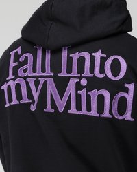 Zwarte hoodie met grote, geborduurde tekst in paars die op de achterkant "Fall Into myMind" zegt. Het materiaal lijkt zacht met een gladde textuur.