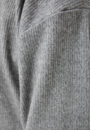 Tissu gris côtelé avec une finition texturée, présentant des lignes verticales et des variations subtiles de teinte. Matériau doux et flexible qui tombe.
