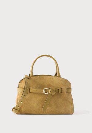 Barna színű velúr kézitáska lekerekített tetejű, dupla fogantyúval, állítható vállpánttal és az elülső övön díszes arany csattal.