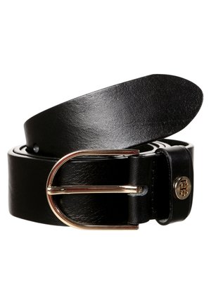 Ceinture en cuir noir roulée avec une boucle métallique ovale dorée et un petit emblème métallique rond près de la boucle de la ceinture.