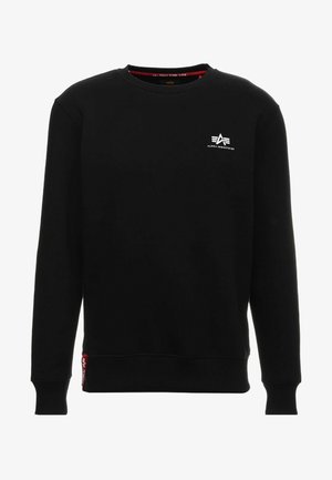 Schwarzer Sweatshirt mit rundem Ausschnitt und langen Ärmeln. Er hat ein kleines weißes Logo auf der Brust und ein rotes Akzentetikett am Saum.