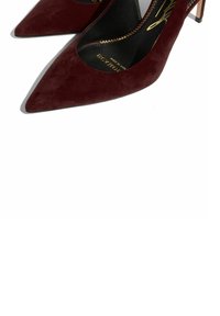 Décolleté in suede bordeaux con punta affilata, tacco sottile e solette nere con bordo zigzag.