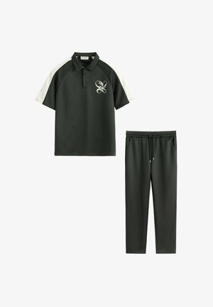Polo vert foncé à manches courtes avec empiècements blancs aux épaules et logo floral, associé à un pantalon à cordon assorti.