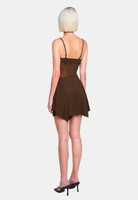 Braunes Kleid mit dünnen Trägern, tailliertem Oberteil und ausgestelltem Rock. Der Stoff wirkt glatt; der Saum ist asymmetrisch und hinten länger!