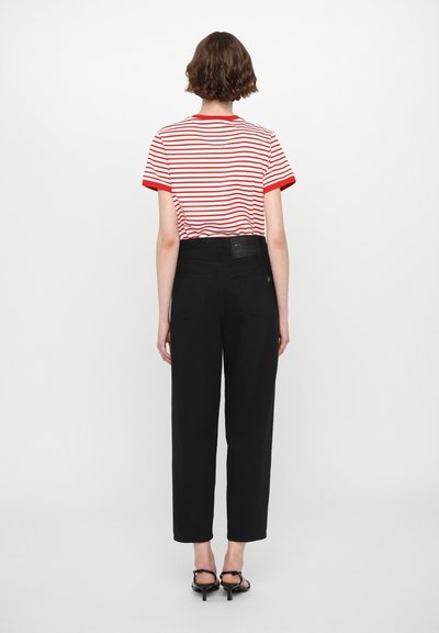 Red and white striped T-shirt with short sleeves, paired with high-waisted black trousers. The outfit features a minimalist design and no visible patterns.
