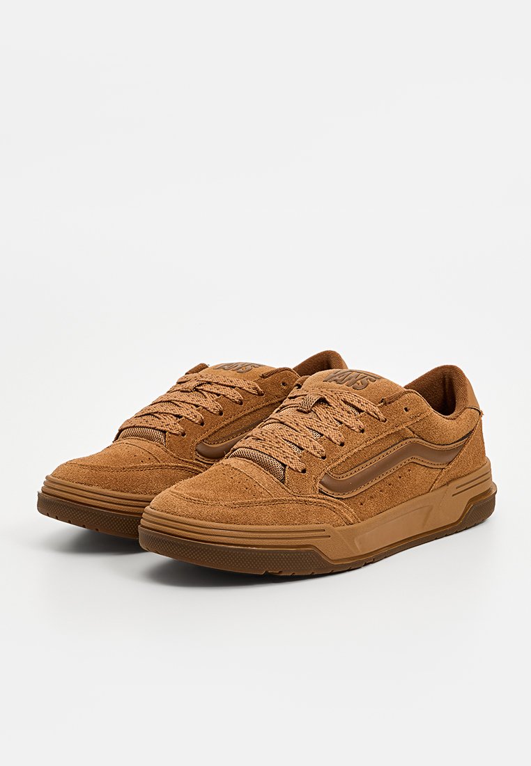 Sneakers in suede marrone con superficie testurizzata, punta tonda e accenti beige a contrasto. Dotati di lacci e suola in gomma a profilo basso.