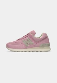 Adidași New Balance roz cu logo și talpă bej, partea superioară din suede și plasă, și design cu șireturi, prezentați din profil lateral.