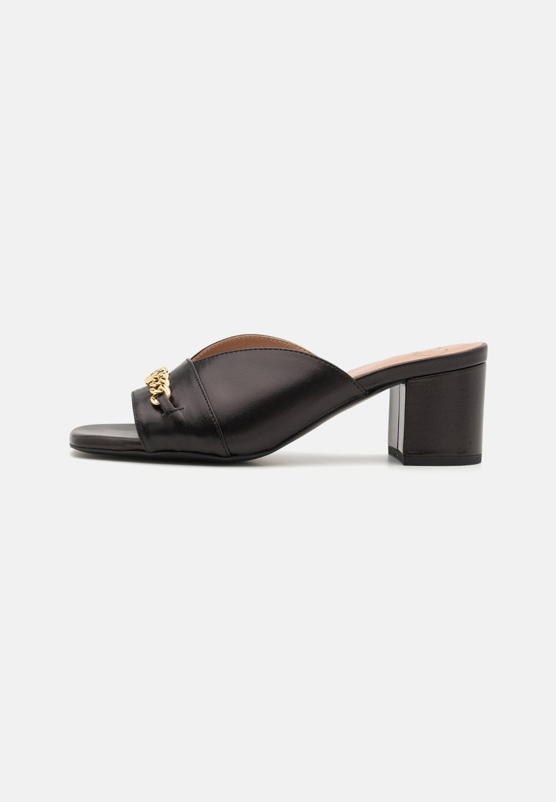 Black leather open-toe slide sandal with a wide strap and gold chain hardware detail. Block heel with a smooth, textured finish.