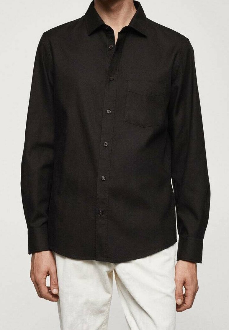 Czarna koszula z długim rękawem, z kołnierzykiem na guziki, pojedynczą kieszenią na piersi i zapinana na guziki z przodu. Materiał wydaje się gładki i lekki.