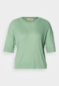 Μυρωδιάς πράσινο πουλόβερ κοντό μανίκι με ριγέ ύφανση, στρόγγυλη λαιμόκοψη και ελαφρώς φαρδιά εφαρμογή. Διαθέτει μια μικρή λογότυπη λεπτομέρεια στη πλευρά.