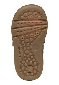 Suola delle scarpe GEOX con un design flessibile, caratterizzata da un materiale in gomma beige, texture a pois e scanalature per la trazione. "FLEXY SYSTEM" impressa.