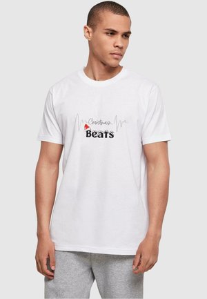 Hvid bomulds t-shirt med "Christmas Beats" grafik i sort og rødt, med et lydbølge mønster over teksten. Korte ærmer og rund hals.