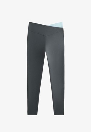 Höga leggings i mörkgrått och ljusblått, tillverkade av stretchigt tyg med en slät textur och sömlös konstruktion.