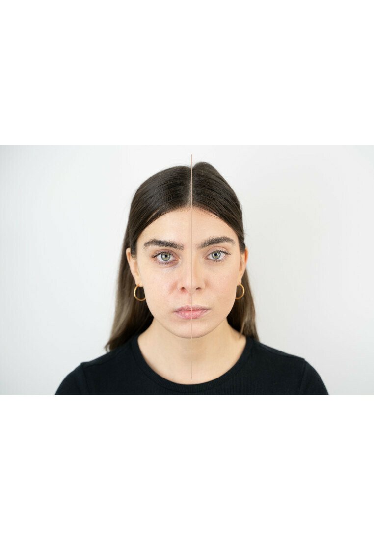 Primo piano di una donna con capelli castani di lunghezza media e occhi verdi, che indossa orecchini a cerchio dorati e una maglietta nera. Vista simmetrica in due parti.