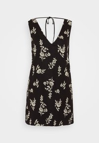 Vestido negro sin mangas con escote en V profundo y cierre de lazo en el cuello. Presenta bordados florales blancos a lo largo de la tela. Corte corto y recto.