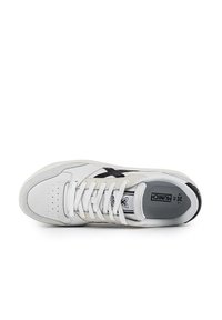 Sneaker bianco in pelle con un accento nero. Presenta punta arrotondata, dettagli perforati e lacci bianchi. Marchio visibile sulla linguetta.