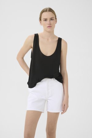 Svart ermeløs topp med en lav utringning; kombinert med hvite denimshorts. Glatt tekstur, avslappet passform, minimal design.