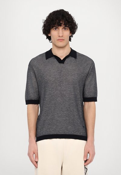 Polo din tricot, în nuanțe de bleumarin și gri, cu decolteu în V și mâneci scurte. Prezentând o guler și manșete întunecate, cu un model texturat pe toată suprafața.