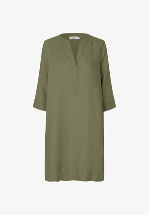 Olivgrön linnetunika med V-ringning, trekvartsärmar och en löst sittande silhuett. Har subtil textur och sidslitsdetaljer.
