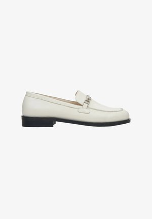 Witte leren loafers met een lage zwarte zool, voorzien van een decoratief zilveren kettingaccent op de bovenkant en gestikte details langs de randen.