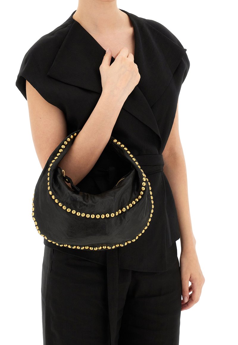 Borsa in pelle nera a forma di mezzaluna con dettagli in borchie dorate lungo i bordi. La borsa ha una consistenza morbida ed è dotata di chiusura con zip.