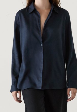 Camicia button-up di satin blu navy con colletto, maniche lunghe e vestibilità rilassata. Presenta una parte anteriore parzialmente aperta e un leggero lucido.