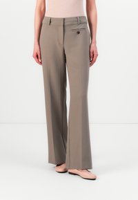 Beige taillierte Hosen mit geradem Bein, mit einem Reißverschluss und Knopfverschluss vorne sowie einem einzelnen Seitentaschen-Detail. Glatte Stofftextur.