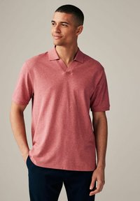 Kurzarm-Polohemd aus meliertem roten Baumwollmix, mit V-Ausschnitt und lockerer Passform. Glatte Textur mit minimalen Nähten.