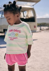 Cotton green and white striped T-shirt with "FUN DAYS" print, paired with pink terrycloth shorts with white trim, worn by a child.