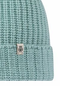 Light blue knitted beanie with a ribbed texture and a folded cuff, featuring a small cream tag with a black emblem.