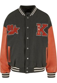 Teksturert svart ullblandings varsityjakke med oransje lærermarmer, broderte lapper, trykknapper og stripete ribbestrikkede mansjetter og krage.