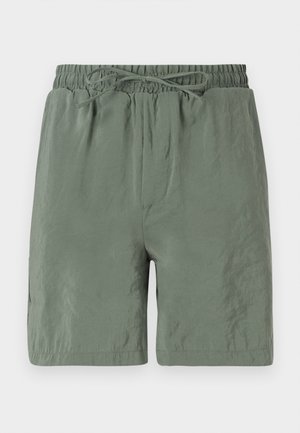 Groene zwembroek met een elastische tailleband en een trekkoord, van lichtgewicht materiaal en met een gladde textuur. Korte lengte met zijzakken.