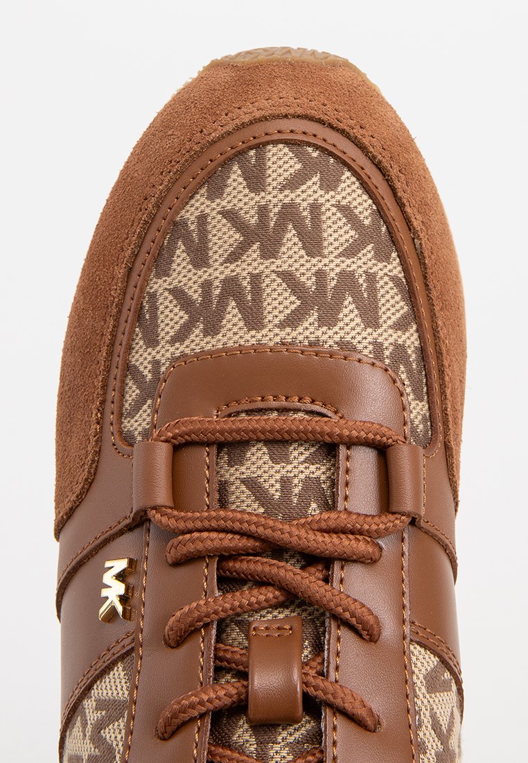 Brauner Sneaker mit Obermaterial aus Wildleder und Stoff, das ein Monogrammmuster aufweist, runde Zehen, Schnürverschluss und metallisches Logo-Detail.