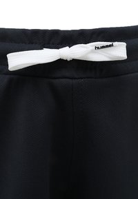 Svarta träningsshorts med nätstruktur, utrustade med en vit dragsko och ett märke från Hummel vid midjan.