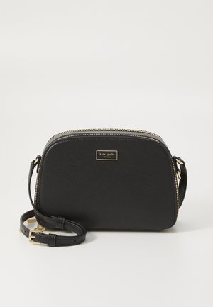 Czarna torba na ramię Kate Spade z złotym zamkiem błyskawicznym, regulowanym paskiem i małą tabliczką z logo z przodu.