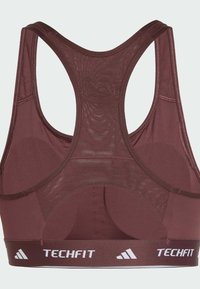 Bordeaux sportbeha met een mesh achterkant, racerback ontwerp en een witte "TECHFIT" logo op een brede elastische band aan de onderkant.
