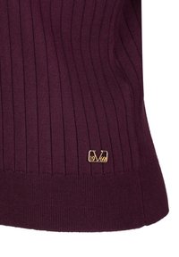 Bordeaux geribbelde trui met een aansluitend model. Voorzien van een gouden logoaccent met "1969" aan de zoom. Zacht, gestructureerd stofdetail.