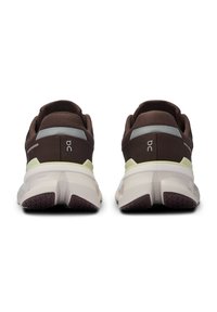 Brown athletic shoes with a textured upper, reflective accents, and a multi-layered sole featuring a white base and purple tread.