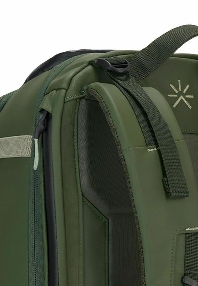 Sac à dos vert avec un extérieur texturé, des bretelles réglables et un emblème de logo. Inclus plusieurs compartiments et une finition en tissu durable.